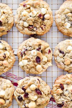 cookies with cranberries and white chocolate chips are cooling on a wire rack, ready to be eaten