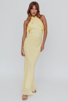 a woman wearing a yellow dress with one shoulder and ruffles on the top