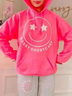 We are so excited to release our newest merch item! The Sassy Star Smiley hoodie is a hot pink sweatshirt with a white smiley face with star eyes. She also features the text "Sassy Shortcake" in white. Rep your favorite brand in this super cute crew!! Oversized fit + unisex sizing. Model is wearing a size small. Trendy Relaxed Fit Sweatshirt With Smiley Face, Preppy Hoodies, Smiley Hoodie, Sassy Shortcake, Hot Pink Sweatshirt, Cute Summer Wallpapers, Preppy Clothes, Preppy Pink, Star Eyes