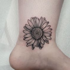 a black and white photo of a sunflower on the foot