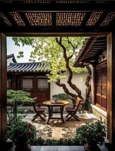 an outdoor table and chairs in the middle of a courtyard with potted plants on either side