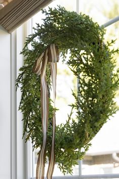 a wreath hanging on the side of a window