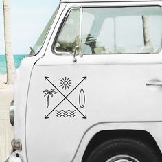 a white van parked on top of a sandy beach next to the ocean and palm trees