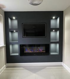 an empty living room with a fireplace and built - in entertainment center on the wall