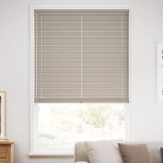 a living room with a couch and window blinds