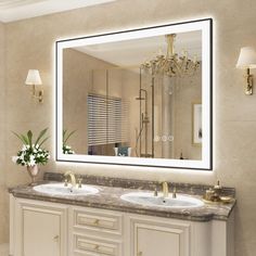 a bathroom vanity with two sinks and a large mirror above it, along with a chandelier