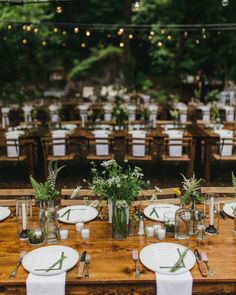 the tables are set with place settings and flowers in vases on each table, along with white linen napkins