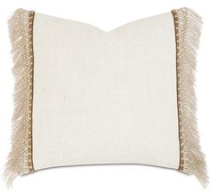 a white and tan pillow with fringe trim