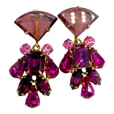 This is part of Chairish’s Costume Jewelry assortment.  When you see those carefully cut and polished triangle cabouchons you know you are looking at one of the design hallmarks of Juliana D &E. This pair is so pretty with magenta, violet, purple, pink and amethyst cut crystal.  All are carefully secured and fully pronged.  Set in russian gold plated base with spring back clip. 2.75" long. Formal Teardrop Jeweled Earrings, Formal Teardrop Earrings With Jewels, Faceted Long Drop Earrings For Party, Faceted Drop Earrings For Evening, Jewelry Closet, Glow Jewelry, Crystal Dangle Earrings, Antique Earrings, Lovely Jewellery