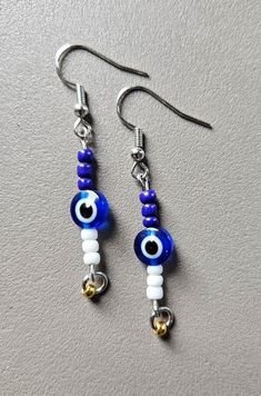 Evil eye earrings Sterling Silver Evil Eye Dangle Earrings, Blue Sterling Silver Evil Eye Earrings, Elegant Dangle Earrings With Evil Eye, Blue Evil Eye Dangle Earrings, Blue Round Evil Eye Earrings, Silver Round Evil Eye Earrings, White Evil Eye Dangle Jewelry, Evil Eye Round Earrings For Gift, Gift White Earrings With Diamond Eyes