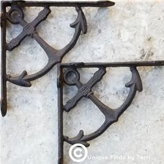 two decorative iron brackets on a marble wall