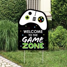 welcome to the game zone sign in front of some bushes and grass with plants behind it