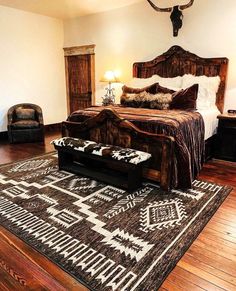 a large bed sitting on top of a wooden floor next to a chair and lamp