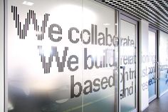 an office with glass walls and black lettering on it