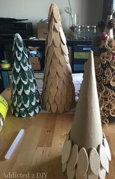 three wooden trees sitting on top of a table next to other christmas tree shaped objects