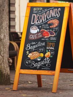 a blackboard sign sitting next to a tree