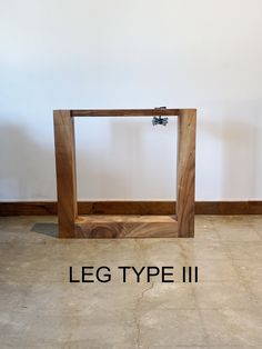 a wooden frame sitting in the middle of a room with an inscription below it that reads leg type ii