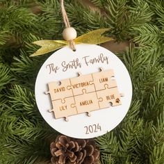 a personalized ornament hanging from a christmas tree with puzzle pieces on it