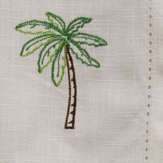 a palm tree embroidered on a white cloth