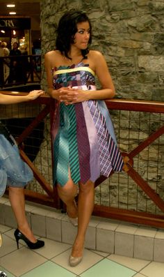 a woman in a dress standing next to a railing