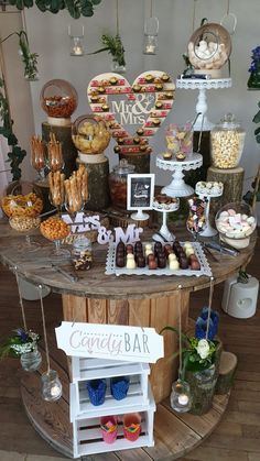 a table filled with lots of desserts and candies on top of wooden boards