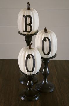 three black and white pumpkins with the letter e on them sitting on a table