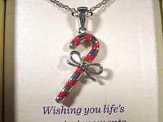 a red and white candy cane necklace in a gift box with a card saying, wishing you life's sweet moments