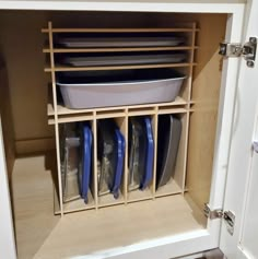 an open cabinet with dishes and pans in it