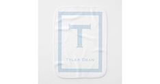 a white towel with the letter t on it and blue trimmings is shown in front of a white background