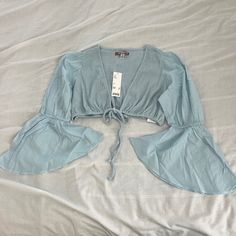 Urban Outfitters Self Tie Crop Top Size Medium Condition: Nwt Color: Light Blue Details : - Bell Sleeves - Front Tie In Front - Perfect On Your Own Or With A Tank Or Bralette Under Extras: - I Ship Between 1-2 Days Light Blue Crop Top For Beach In Spring, Light Blue Crop Top For Beach And Spring, Light Blue Cropped Summer Blouse, Light Blue Cropped Blouse For Summer, Light Blue V-neck Crop Top For Summer, Urban Outfitters V-neck Summer Blouse, Spring V-neck Light Blue Crop Top, Blue Spring Crop Top For Brunch, Trendy Summer Blouse By Urban Outfitters