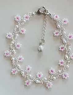 Handmade flower bracelet using quality Japanese and/or Czech seed beads in translucent white and fuschia. In-between are faux pearls and square glass beads. The ends are finished with a silvertone heart shaped lobster claw clasp and a stainless steel extension chain with faux pearl charm. This bracelet measures approximately 7.5" with an additional 1" extender chain. Protect from excess moisture such as water, sprays and lotions. Handmade White Pearl Bracelet With Flower Shape, Handmade White Pearl Flower Bracelet, Handmade White Flower Pearl Bracelet, White Beaded Pearl Bracelet With Flower Shape, White Beaded Pearl Bracelet With Flower Design, White Beaded Flower Pearl Bracelet, Pink Pearl Jewelry With Tiny Beads, Delicate White Flower Pearl Bracelet, White Beaded Chain Pearl Bracelet Gift