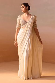 Ivory satin pre-draped saree with pearl-dori-sequin tassel embellishment on the shoulder. Paired with a half sleeves floral dori-pearl-bead embroidered blouse. - Aza Fashions