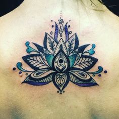 the back of a woman's chest with a tattoo design on her left side