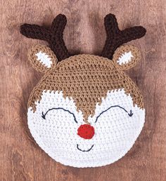 a crocheted deer hat with red nose and antlers on it's head