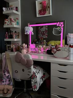 a hello kitty themed desk and chair in a room with pink lighting on the mirror