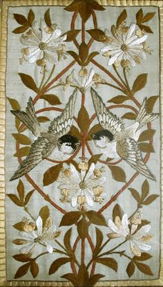 two birds sitting on top of a white and brown flowered wall hanging from a wooden frame