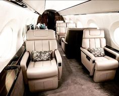 the inside of an airplane with leather seats and pillows on it's back end