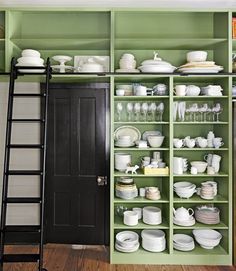 there are many shelves in the kitchen with dishes on them