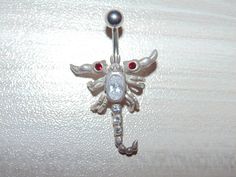 "Link to store: https://www.etsy.com/shop/VintageJewelryEden SOLD SEPARATELY New Handmade Belly button ring Shape: Moveable Scorpion / Leaping Dolphins(sold) / Iguana Lizard / Clear and Blue Spiders Barbell is standard 14 gauge, 3/8\" long made of hypoallergenic surgical stainless steel Dangle elements are sterling silver, stamped 925 All crystal cubic zirconia Colors: Various SHIPPING WORLDWIDE" Scorpion Belly Button Ring, Silver Jeweled Body Jewelry Gift, Silver Jeweled Body Jewelry For Gifts, Adjustable Rhinestone Body Jewelry Gift, Adjustable Rhinestone Body Jewelry For Gift, Adjustable Silver Jeweled Body Jewelry, Piercing Inspiration, Piercing Bar, Bellybutton Piercings