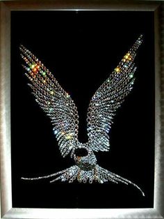 an image of a bird made out of beaded beads on a black background in a silver frame