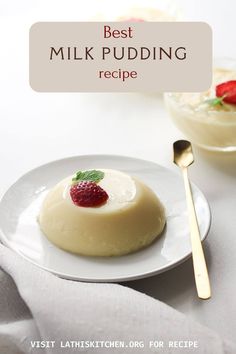 a white plate topped with pudding next to a bowl of strawberries and a spoon