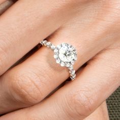 a woman's hand with a diamond ring on top of her finger and an engagement band