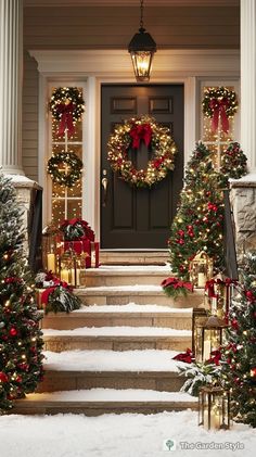 christmas wreaths and lights on the front steps of a house