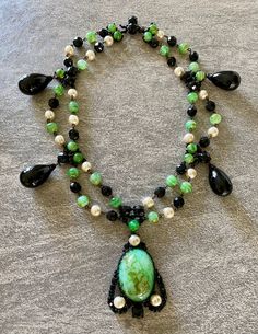 An unusual and very rare early 1960's Necklace created by Roger Scemama for Christian Dior . This is such a beautiful and stunning rare necklace with gorgeous colour combination of green and black poured glass on a japanned metal structure makes this a stand out example of the early work of Roger Scemama  from the early 1960s . The last few pictures are taken from the book Adorning Fashion by Deanna Farneti Cera, page 305 listing the brooch as a signed Christian Dior 1960 and also from an auctio Elegant Evening Cabochon Necklaces, Formal Green Cabochon Necklace, Luxury Green Cabochon Necklace, Green Gemstone Necklace For Evening, Elegant Green Necklace For Evening, Green Cabochon Jewelry For Party, Elegant Green Double Strand Jewelry, Elegant Green Necklaces With Natural Stones, Elegant Green Necklace With Natural Stones