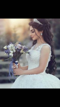 a woman in a wedding dress holding flowers