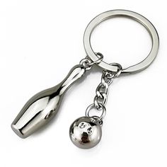 a metal keychain with a bowling ball and bat on it's side