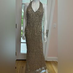 a mannequin wearing a gold dress in front of a door