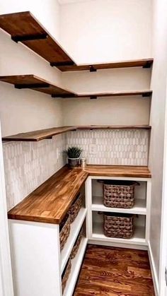 an empty pantry with wooden shelves and baskets