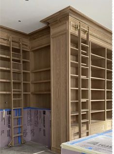 an empty room with wooden bookcases in the process of being built and painted