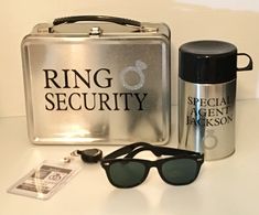 the sunglasses are next to an aluminum case and some other items on a white table